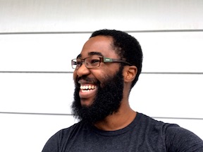 Farai with a bushy beard, smiling